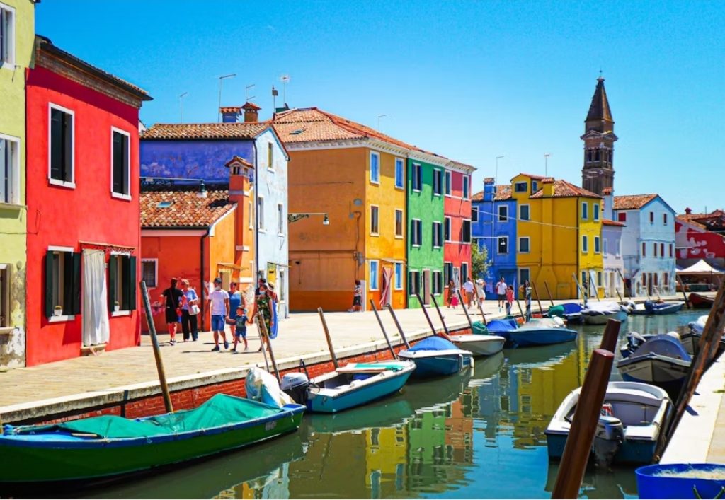 Colorful houses reflected in the canal on Burano island, Venice.